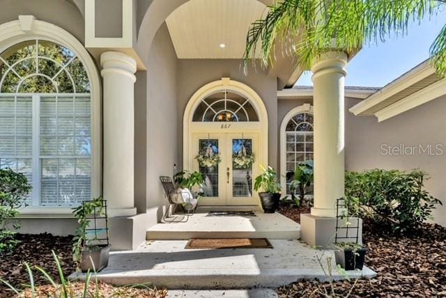 doorway to property featuring french doors and stucco siding