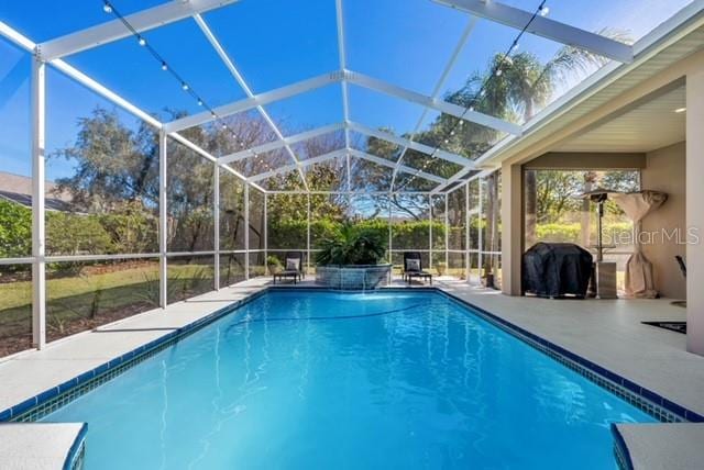 pool featuring area for grilling, a lanai, and a patio area