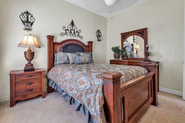 bedroom with light colored carpet, baseboards, and ceiling fan