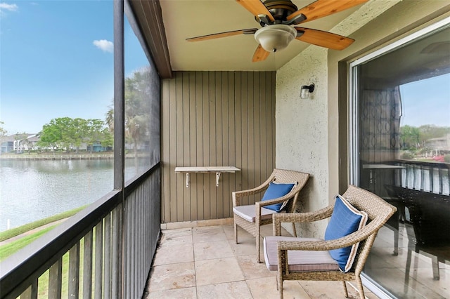 balcony with a water view and ceiling fan