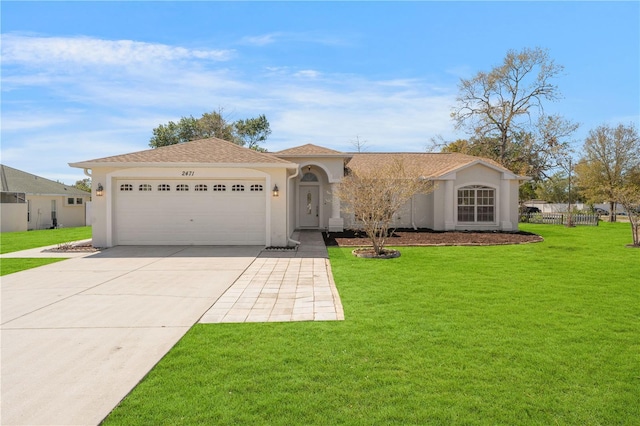 view of front of property with a front yard, a garage, driveway, and stucco siding