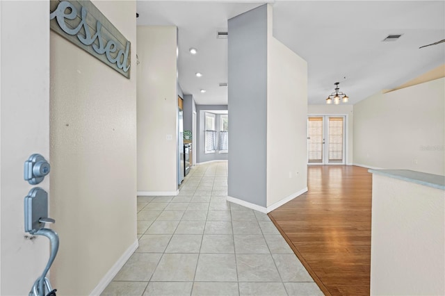 hallway with visible vents, recessed lighting, an inviting chandelier, light tile patterned floors, and baseboards