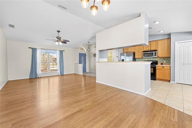 kitchen featuring visible vents, appliances with stainless steel finishes, open floor plan, and vaulted ceiling