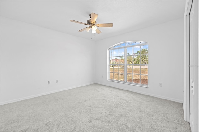 unfurnished room featuring baseboards, carpet, and a ceiling fan