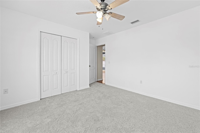 unfurnished bedroom featuring light carpet, visible vents, baseboards, and a closet