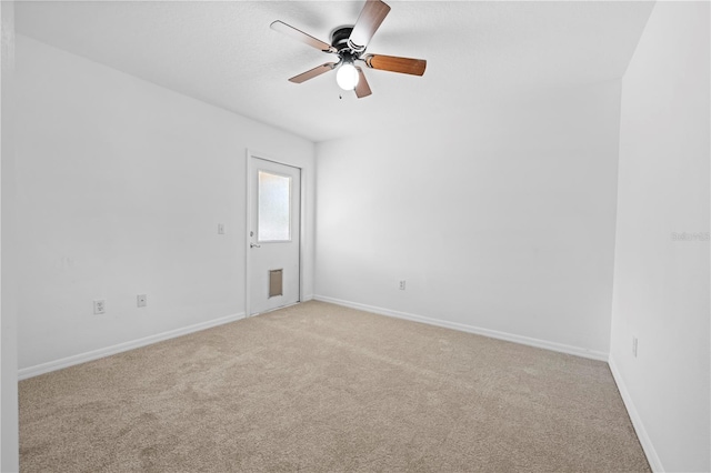 unfurnished room featuring light colored carpet, baseboards, and a ceiling fan