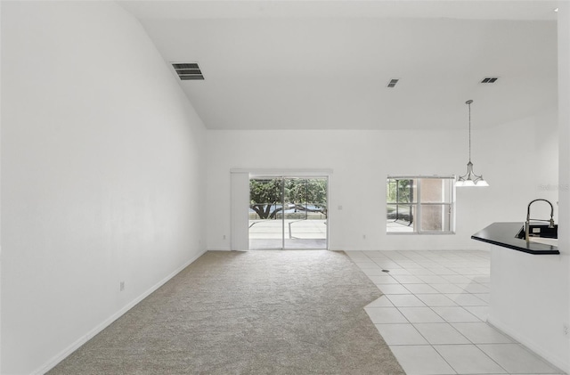 unfurnished living room featuring light tile patterned floors, visible vents, and light colored carpet