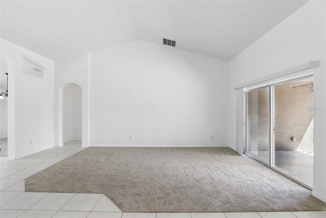 unfurnished bedroom featuring visible vents, high vaulted ceiling, arched walkways, tile patterned flooring, and carpet flooring