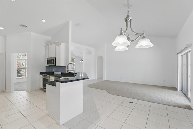 kitchen with visible vents, a notable chandelier, stainless steel appliances, arched walkways, and light tile patterned flooring