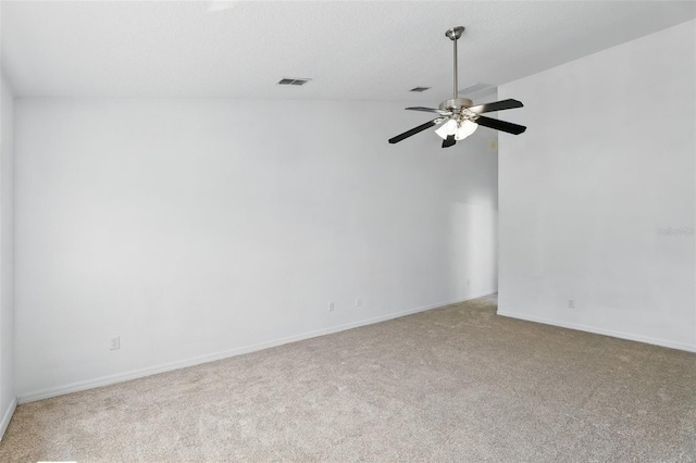 carpeted empty room featuring baseboards, visible vents, and ceiling fan