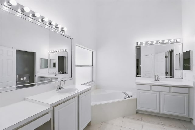 bathroom featuring a sink, a garden tub, two vanities, and tile patterned floors