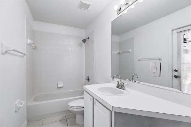 bathroom with visible vents, toilet, vanity, tile patterned floors, and a textured ceiling