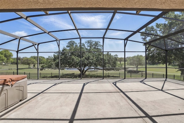 view of patio featuring glass enclosure and fence