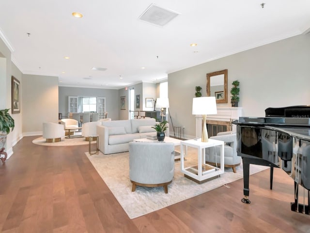 living area featuring recessed lighting, wood finished floors, baseboards, and ornamental molding