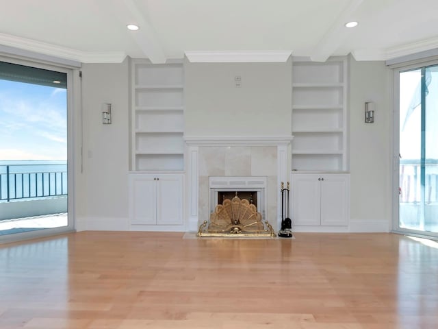 unfurnished living room featuring built in features, beamed ceiling, crown molding, and baseboards