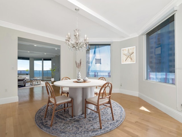 dining space featuring a chandelier, light wood-style flooring, and crown molding