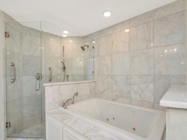 full bath with recessed lighting, a tub with jets, a shower stall, and tile walls