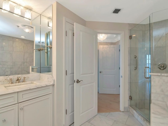 bathroom with visible vents, a shower stall, and vanity