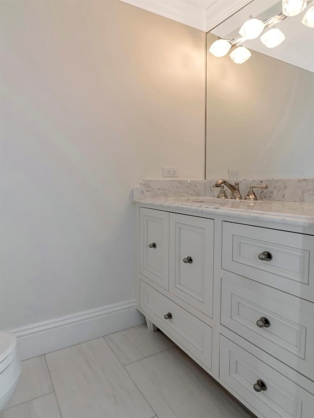 half bath featuring vanity, toilet, baseboards, and marble finish floor