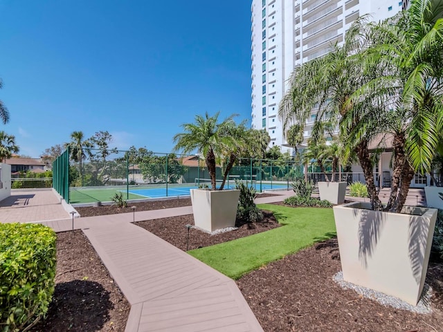 surrounding community with a tennis court and fence