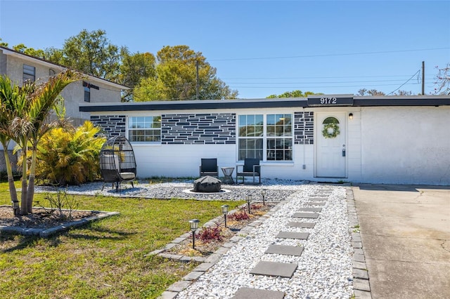 rear view of house featuring a yard and an outdoor fire pit