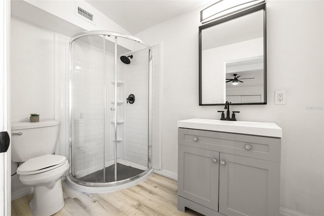 bathroom featuring visible vents, toilet, wood finished floors, and a stall shower