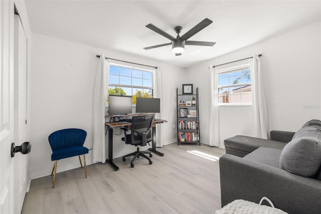 home office featuring baseboards, light wood finished floors, and ceiling fan