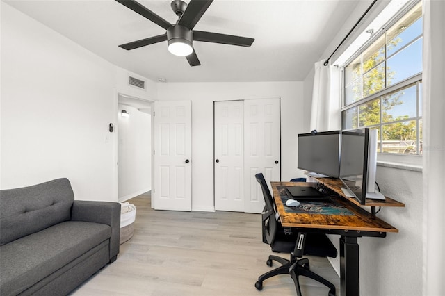 office area featuring baseboards, visible vents, light wood finished floors, and ceiling fan