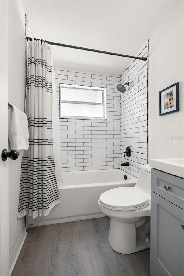 bathroom with toilet, shower / bath combo with shower curtain, vanity, and wood finished floors