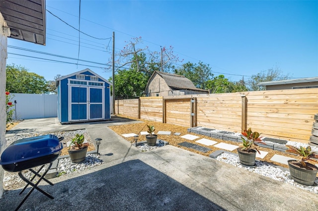 view of patio / terrace featuring area for grilling, an outdoor structure, a storage shed, and a fenced backyard