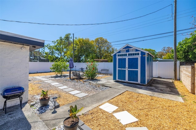 view of yard with an outbuilding, a shed, and a fenced backyard