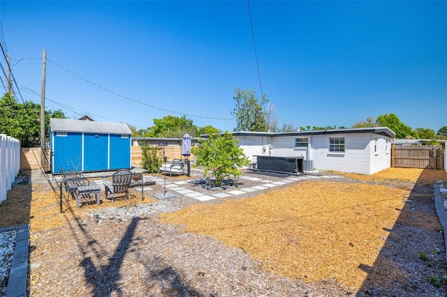 back of property with an outbuilding, a fenced backyard, and a shed