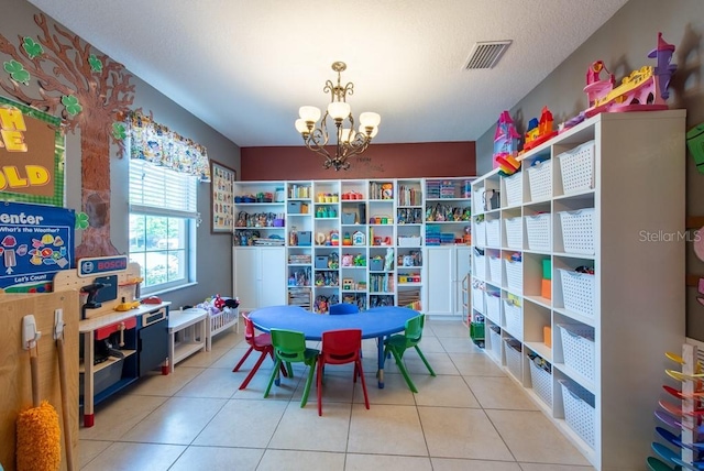 game room featuring a textured ceiling, tile patterned floors, visible vents, and a chandelier