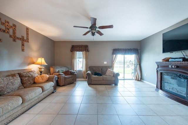 tiled living area with a ceiling fan and baseboards