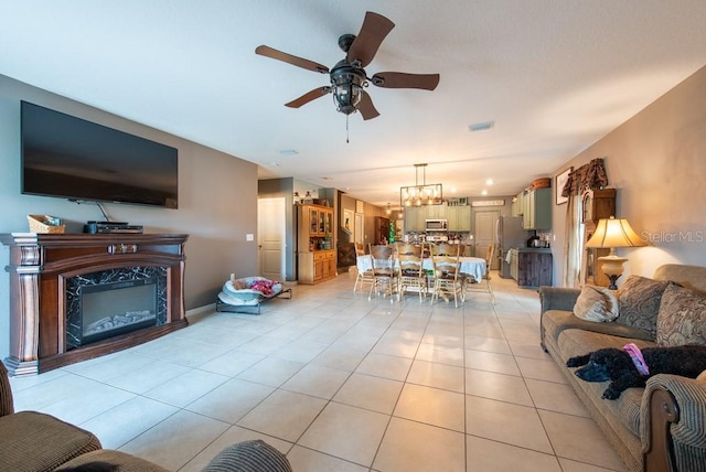 living room featuring light tile patterned flooring, ceiling fan, and a premium fireplace