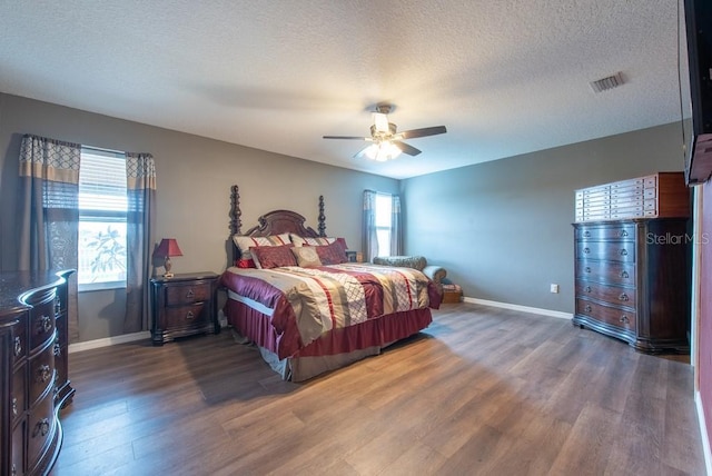 bedroom with visible vents, multiple windows, baseboards, and wood finished floors