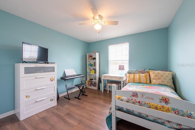 bedroom with ceiling fan, baseboards, and wood finished floors