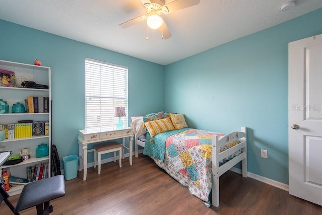 bedroom with a ceiling fan, wood finished floors, and baseboards