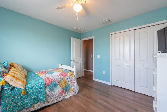 bedroom featuring wood finished floors, visible vents, baseboards, ceiling fan, and a closet