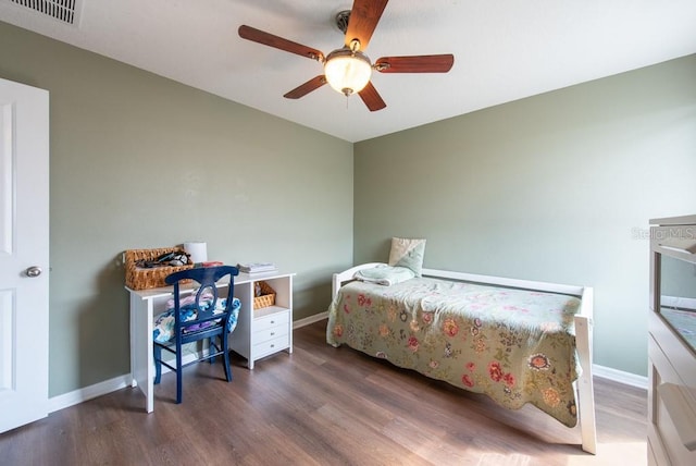 bedroom with a ceiling fan, wood finished floors, visible vents, and baseboards