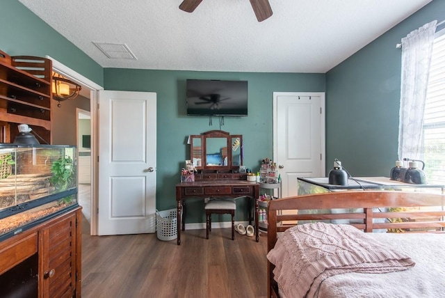 bedroom with visible vents, a textured ceiling, wood finished floors, and a ceiling fan