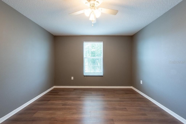 unfurnished room with ceiling fan, a textured ceiling, baseboards, and dark wood-style flooring