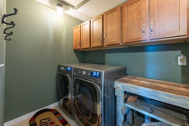 laundry room featuring separate washer and dryer, cabinet space, and baseboards