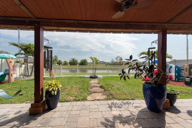 view of patio / terrace featuring fence, a ceiling fan, and a water view