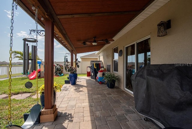 view of patio / terrace with a playground, a grill, fence, and ceiling fan