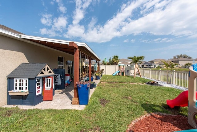 view of yard with a patio, a playground, and a fenced backyard