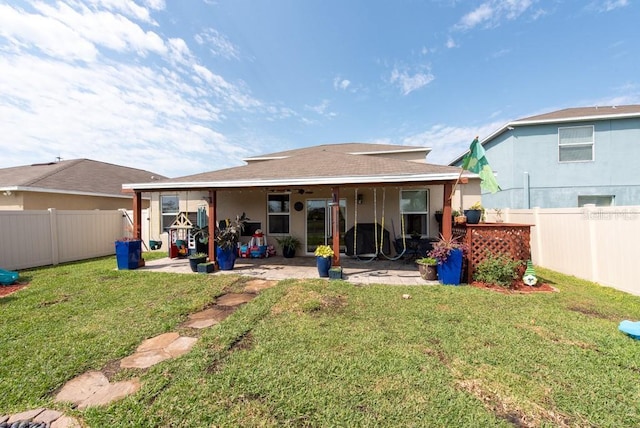 rear view of house with a patio, a lawn, and a fenced backyard