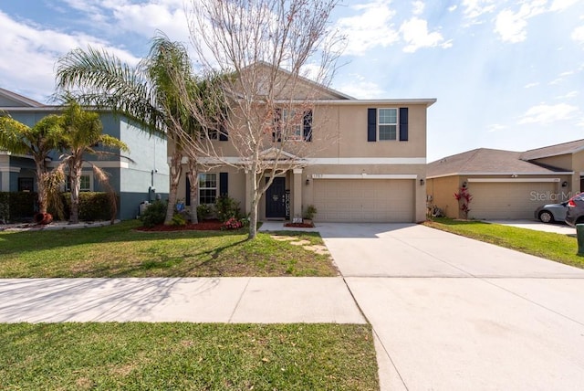 traditional home with stucco siding, an attached garage, concrete driveway, and a front yard