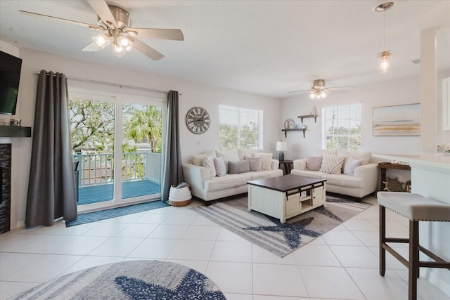 living area featuring light tile patterned floors and ceiling fan