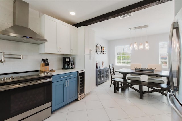 kitchen featuring blue cabinets, wine cooler, light countertops, stainless steel appliances, and wall chimney exhaust hood